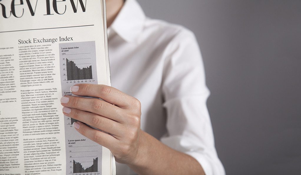 Young woman reading newspaper